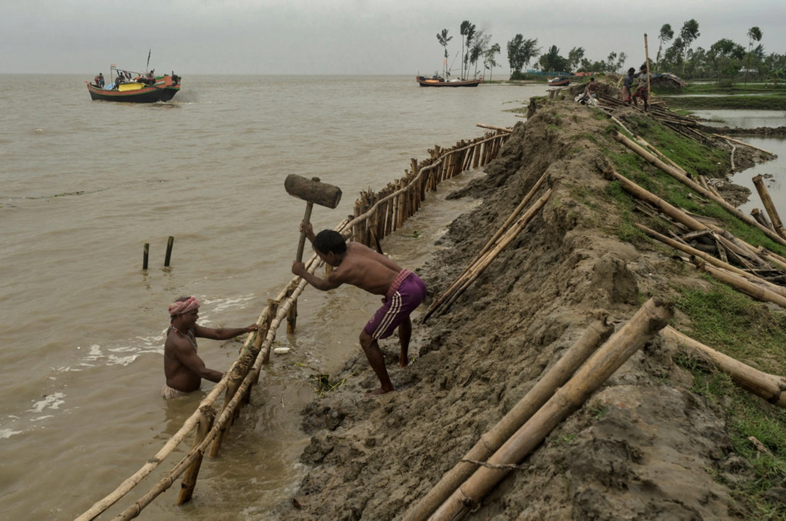 During the high tide the inhabitants of Ghoramara Island are fixing the fragile soil embankment to restrain the further land erosion and the high tide that inundates to the island that is rapidly disappearing due to the sea level rise.