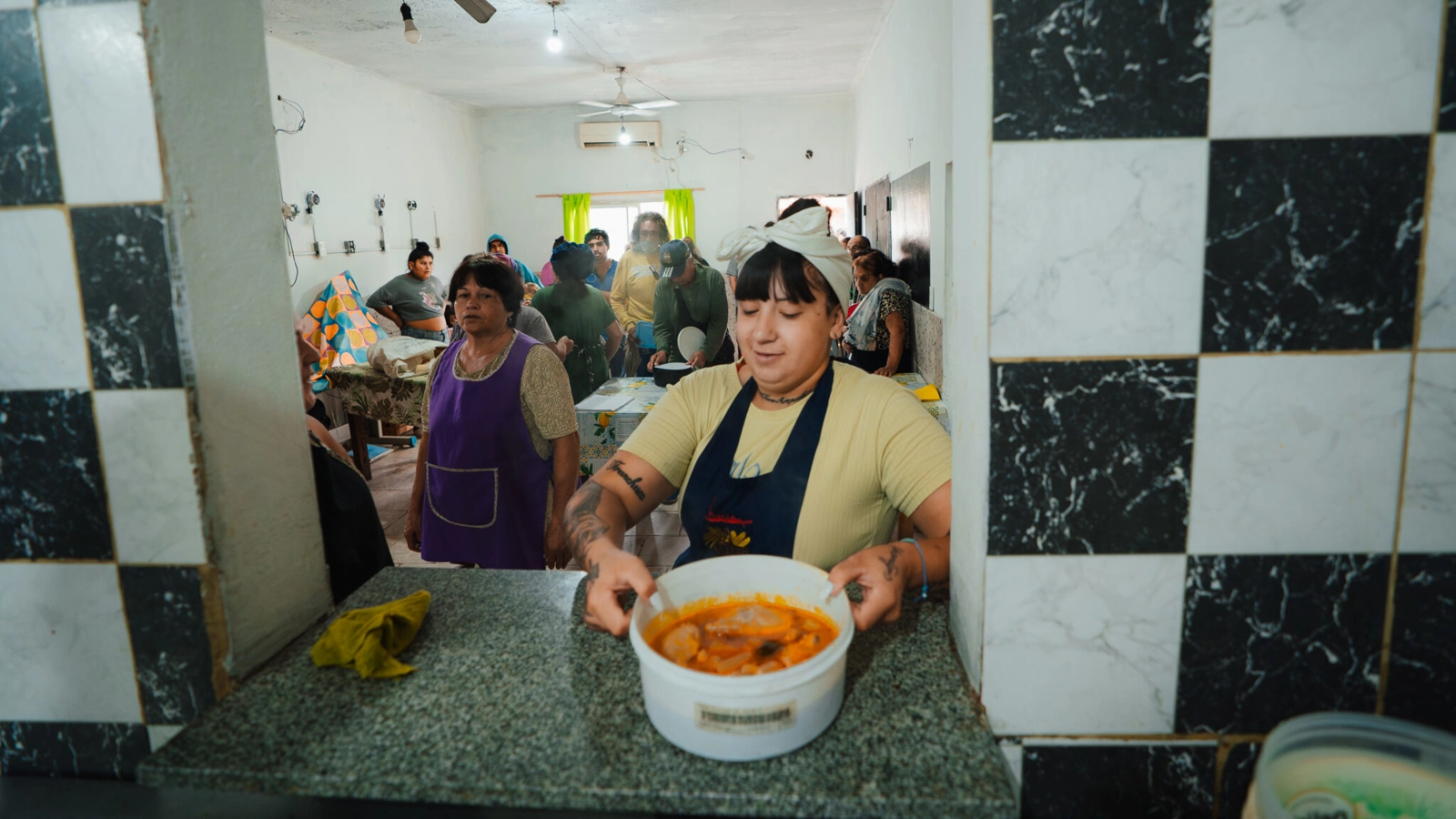 Image: Neighbors receive hot meals and fresh fruit from the 9 de Julio Soup Kitchen, which receives food from Banco de Alimentos Rosario. The soup kitchen feed 700 families per day.